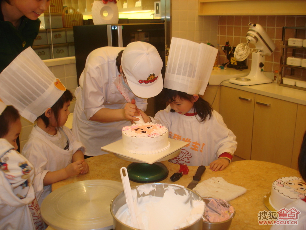 弯弯专心地做蛋糕,这个蛋糕是几个小朋友共同完成的,孩子们站着队