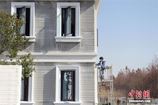 1月19日,工人正在3d打印别墅外部进行施工.
