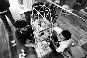 参赛学生在其设计制作的房屋结构模型上加载重物