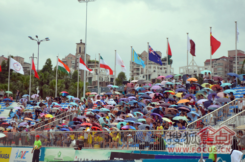 现场下起一阵小雨，大家打伞冒雨观看比赛