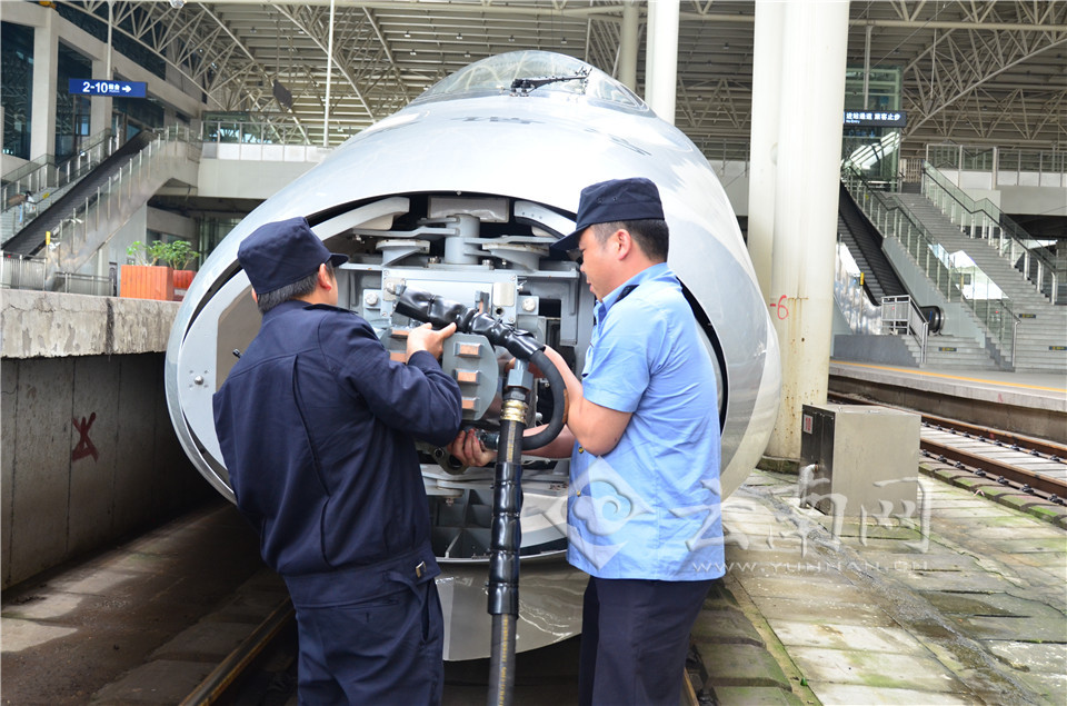 在贵阳北车站,机械师正在安装过度车钩.