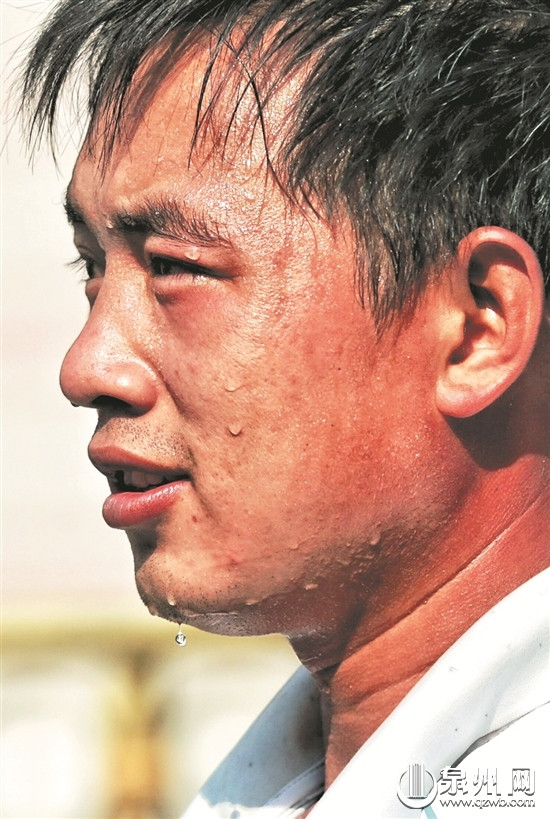 一位市民被晒得满脸通红,汗如雨下.(戴涵琦 摄)