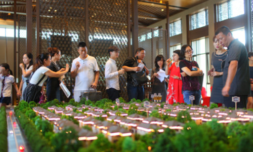 置业顾问在沙盘区为嘉宾认真讲解项目的规划,布局,创新亮点