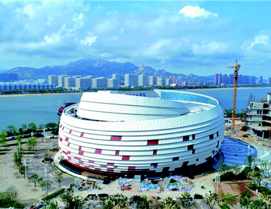 2.记者11月22日从西海岸发展集团获悉,位于青岛西海岸新区灵山湾影视文化产业区内的青岛东方影都大剧院日前竣工,计划于12月正式交付使用。大剧院采用独特的碧海银螺造型,是国内首个采用杜比全景声系统的大剧院,也是世界首个采用杜比全景声和可变混响声学系统结合的大剧院。 大剧院与秀场、珊瑚贝桥相邻,整体设计风格结合青岛当地独特的海洋文化,以富有动感的整体造型、仿生立面肌理和简洁材质运用创造出与海天融为一体的独特气质。 3.