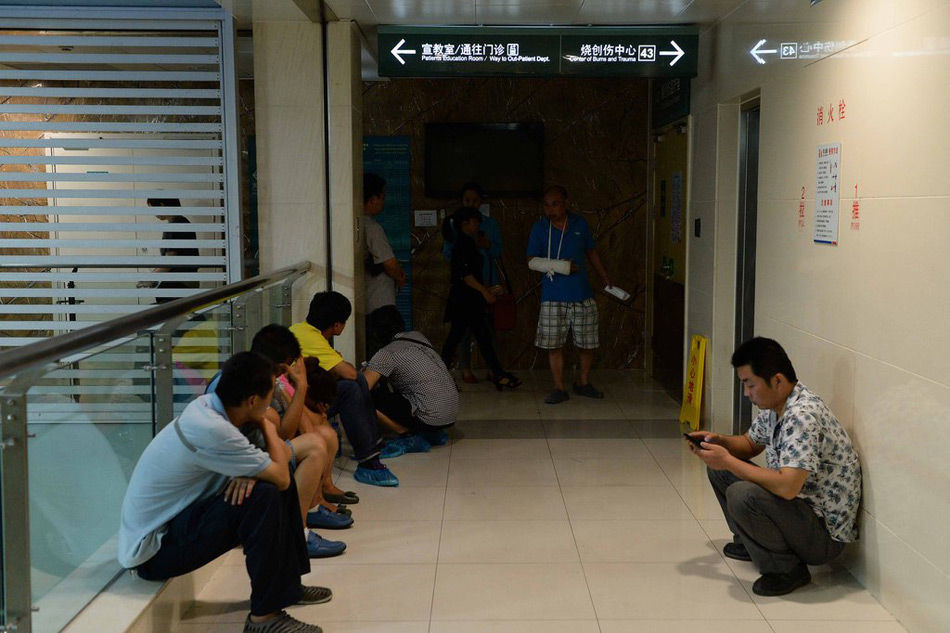 昆山爆炸事故伤员的家属在上海长海医院重症监护室外等候消息