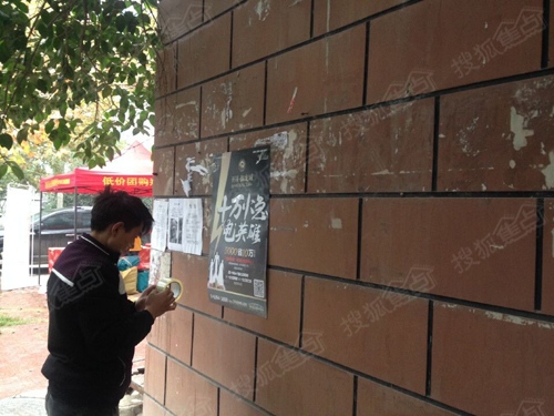 工作人员在小区内贴海报