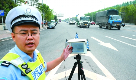 昨日,海尔路寸滩段,交巡警采用移动测速仪对过往车辆进行测速.