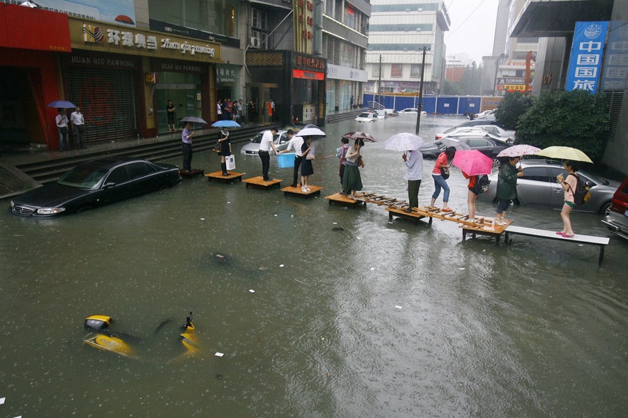 组图:武汉内涝成海 市民过街各显神通