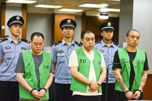 昨日,在法庭上,主犯梁达(右一)和另两名被告人正在听判决结果.